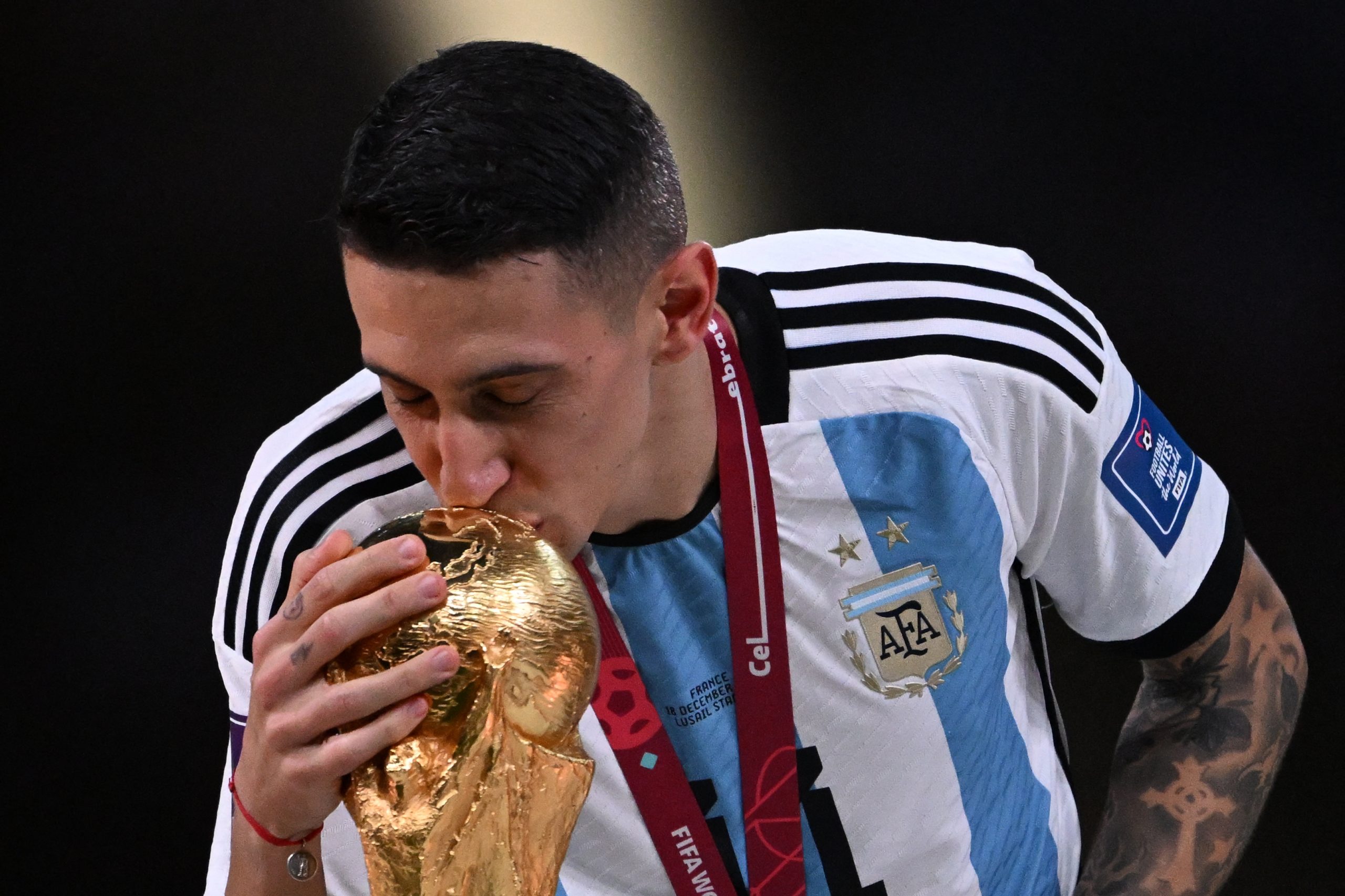 Argentina's midfielder #11 Angel Di Maria kisses the FIFA World Cup Trophy during the trophy ceremony after Argentina won the Qatar 2022 World Cup final football match between Argentina and France at Lusail Stadium in Lusail, north of Doha on December 18, 2022. (Photo by Kirill KUDRYAVTSEV / AFP) (Photo by KIRILL KUDRYAVTSEV/AFP via Getty Images)